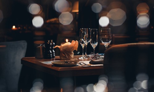 wine glasses and a candle in a warm lit restaurant